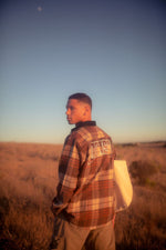 Brown oversized checked shirt Flannel with corduroy collar and pocket flap detail with white defensive logo embroidery on the back with male model 